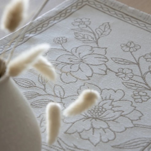 Individual de 30x45 cm con diseño floral en tono beige sobre fondo blanco roto y detalle de cenefa decorativa-URSULA